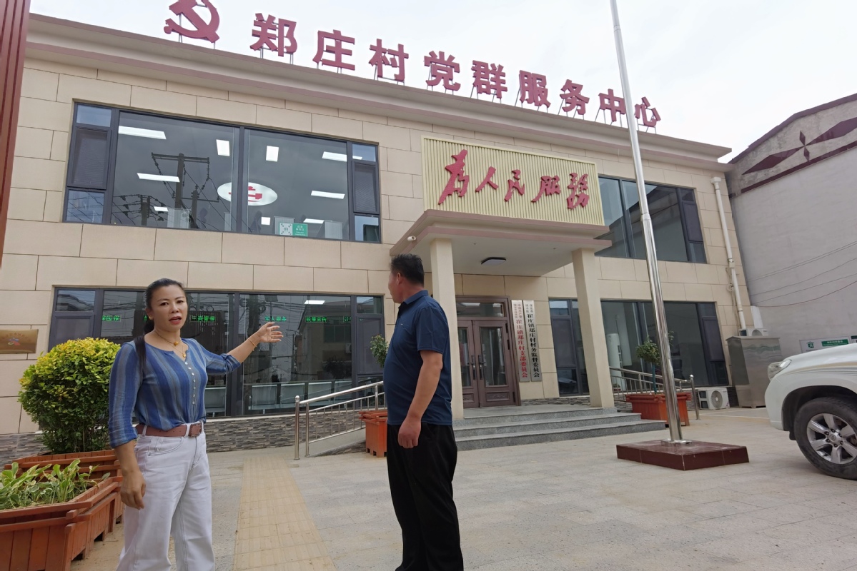 郑庄村党支部书记张俊（左）讲述拆墙透窗的新变化。刘柯旋摄.jpg
