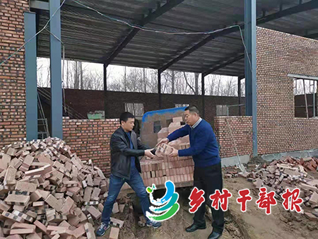 图为义女社区书记刘春雨（右）搬砖帮吕二龙建厂房。3.jpg