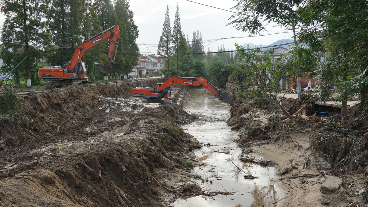 8月21-22日，陕西勉县遭受特大暴雨袭击，图为雨后救援人员在清理渠中淤泥。 新华社发.JPG