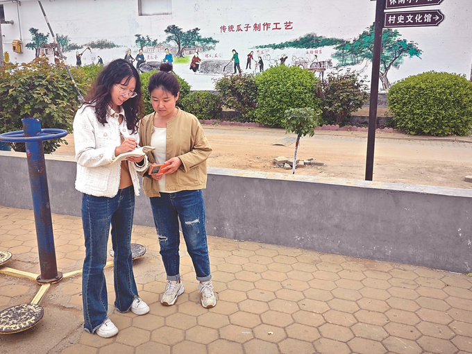石雪怡(左一)和村“两委”成员讨论小广场美化问题。 （故城县委组织部供图）.jpg